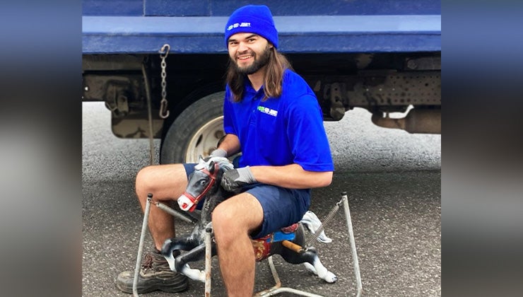 1-800-GOT-JUNK? truck team member sitting on an old toy rocking horse
