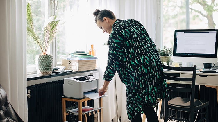 A lady using an old printer in her office