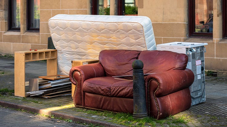 Pile of old furniture set aside on the curb for pick-up