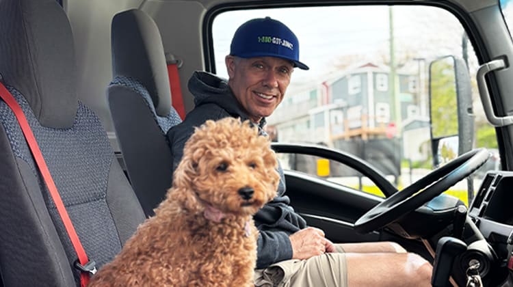 1-800-GOT-JUNK? Franchise Partner, Michael Baldwin, sits with his dog, Ruby, in a 1-800-GOT-JUNK? truck in Newfoundland.