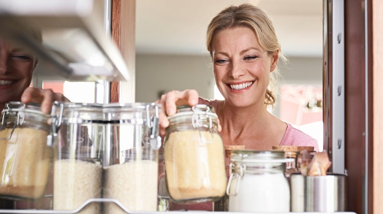 Woman reaching into a pantry for flour 