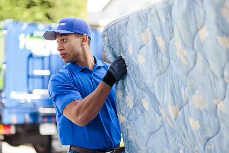 1-800-GOT-JUNK? team disposing of old mattress