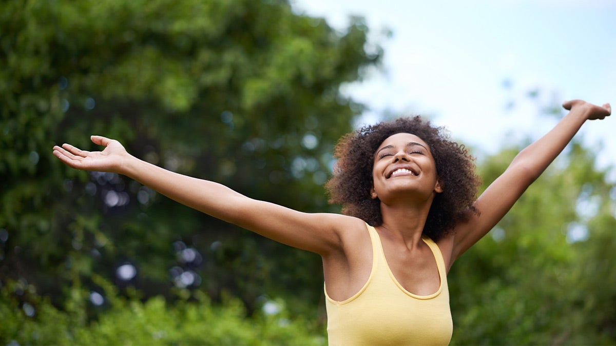 Woman smiling toward the sky outdoors