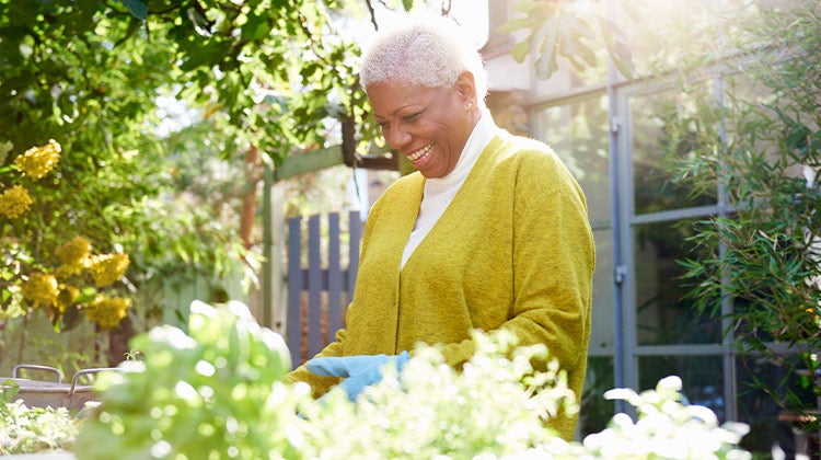Woman smiling while gardening outdoors