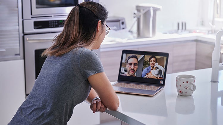 Woman video chatting with friends in her kitchen