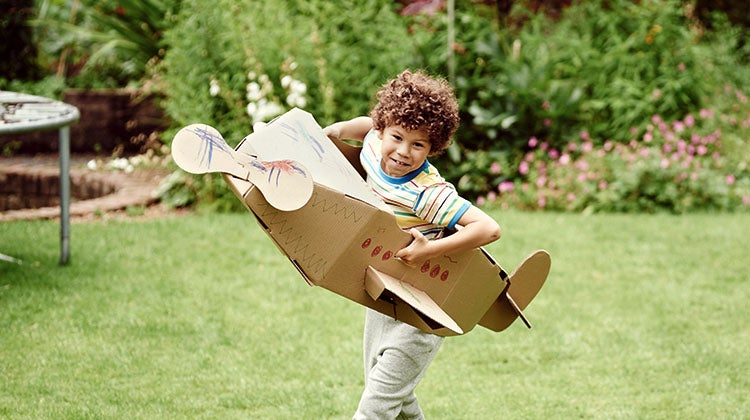 Young boy playing in a cardboard airplane