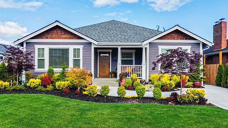 grey house with a green lawn