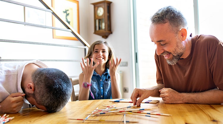 Daughter playing Pick-Up Sticks with her Dads Daughter playing Pick-Up Sticks with her Dads