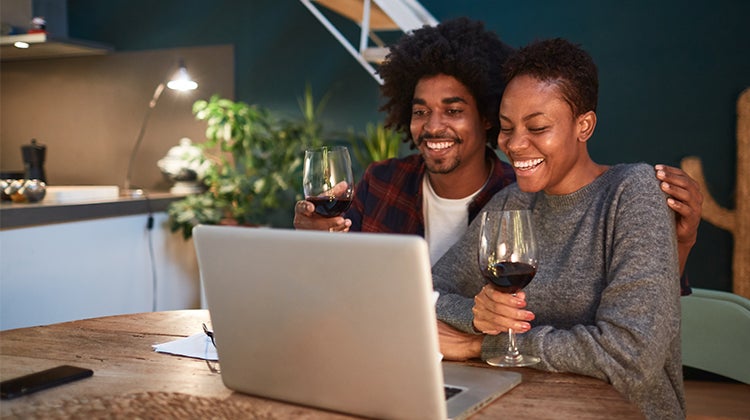 Couple enjoying a virtual wine tasting through video chat 