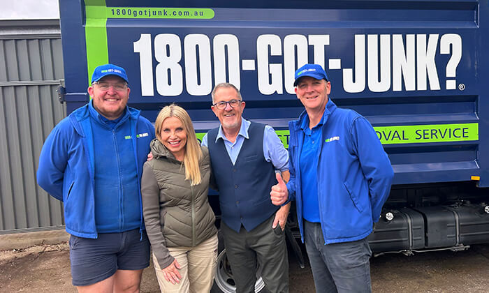 The 1800-GOT-JUNK? Melbourne team with Space Invaders hosts smiling in front of a truck.