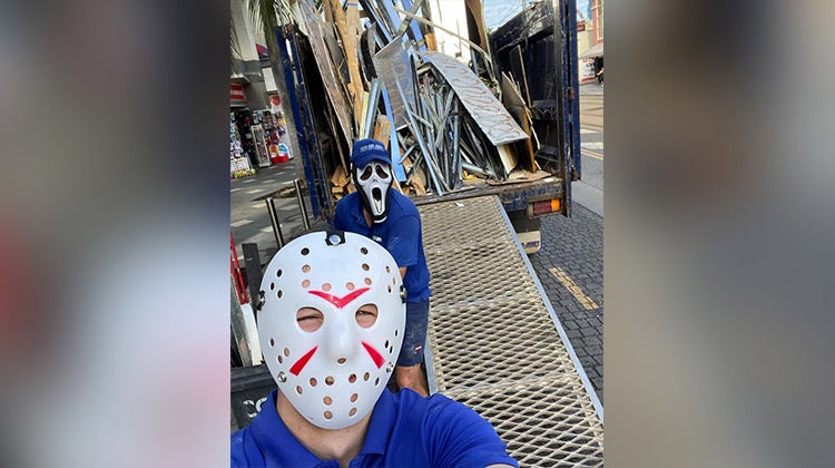 1-800-GOT-JUNK? team members wearing Jason Vorhees and Scream masks