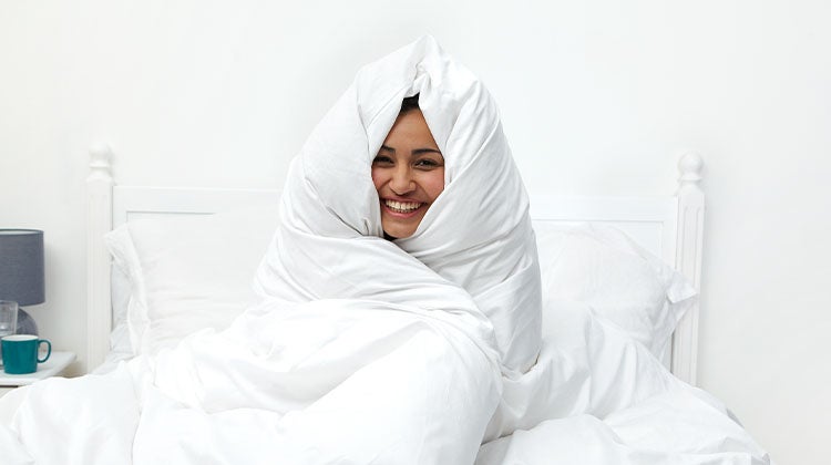 Woman wrapped in a clean white blanket 