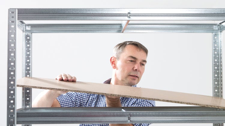 Man installing organizational shelving 