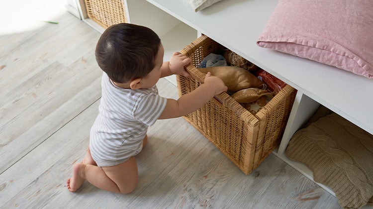 Toddler pulling out a storage box filled with toys
