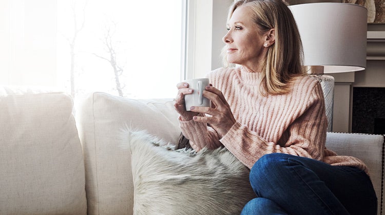 Woman relaxing on a couch while drinking coffee