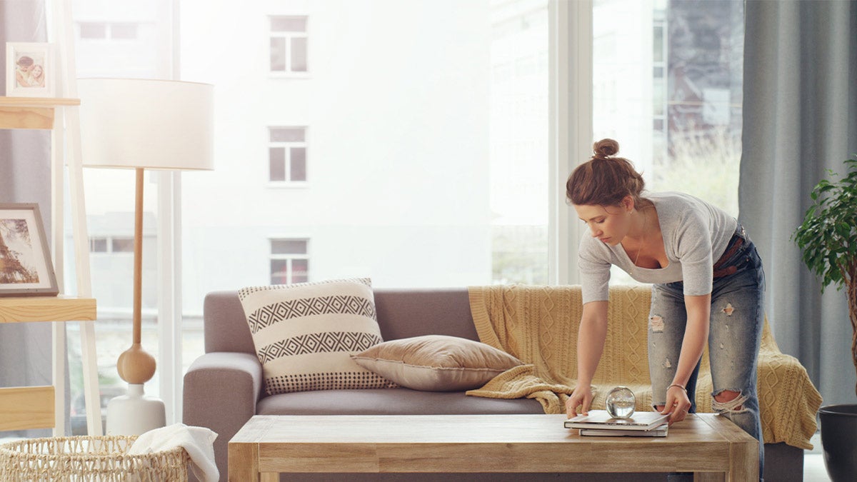 Woman organizing books on a coffee table