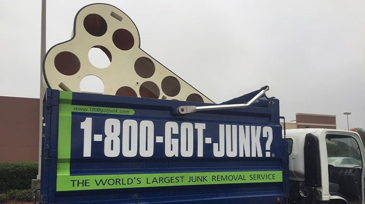 Large bone sculpture sticking out of a 1-800-GOT-JUNK? truck