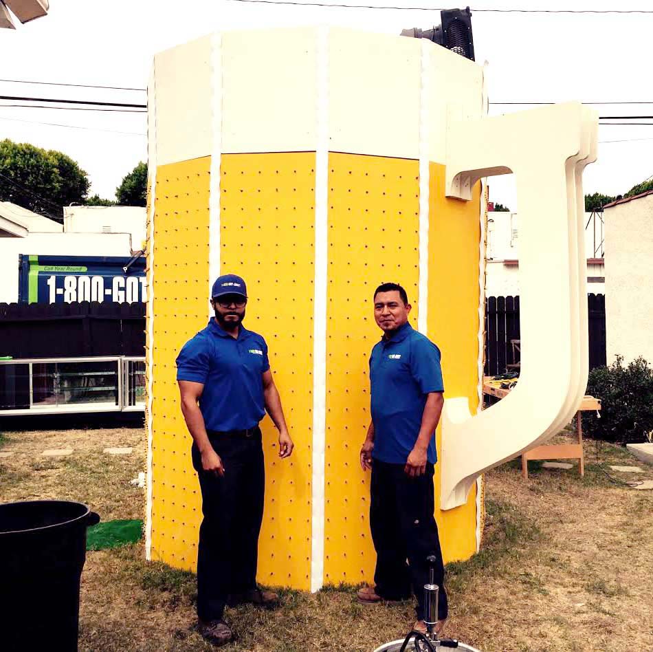 TOMs posing in front of a giant beer mug statue TOMs posing in front of a giant beer mug statue