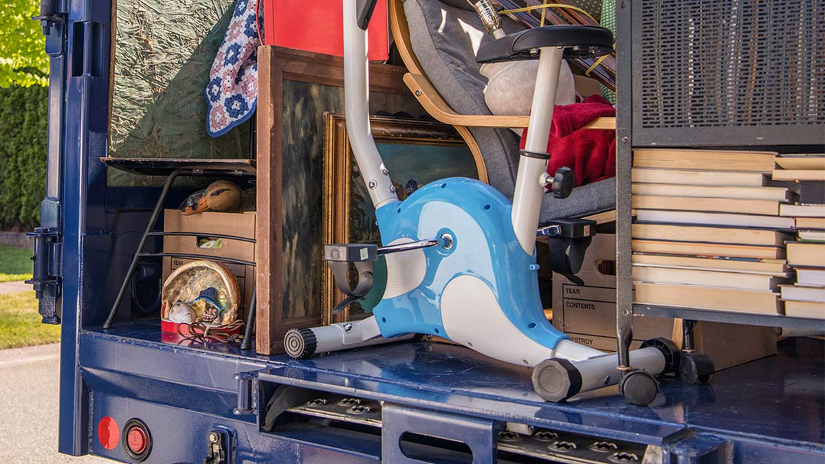 Exercise bike and junk items piled in a large truck 