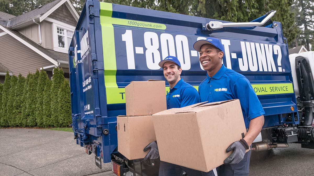 Truck Team Members carrying boxes beside 1-800-GOT-JUNK? truck