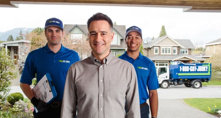 Founder Brian Scudamore standing beside two 1-800-GOT-JUNK? team members.