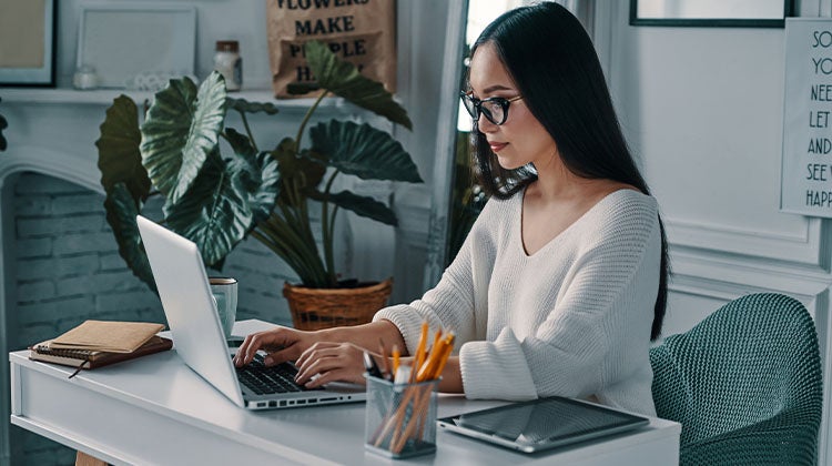 Woman sitting at her desk working on a laptop